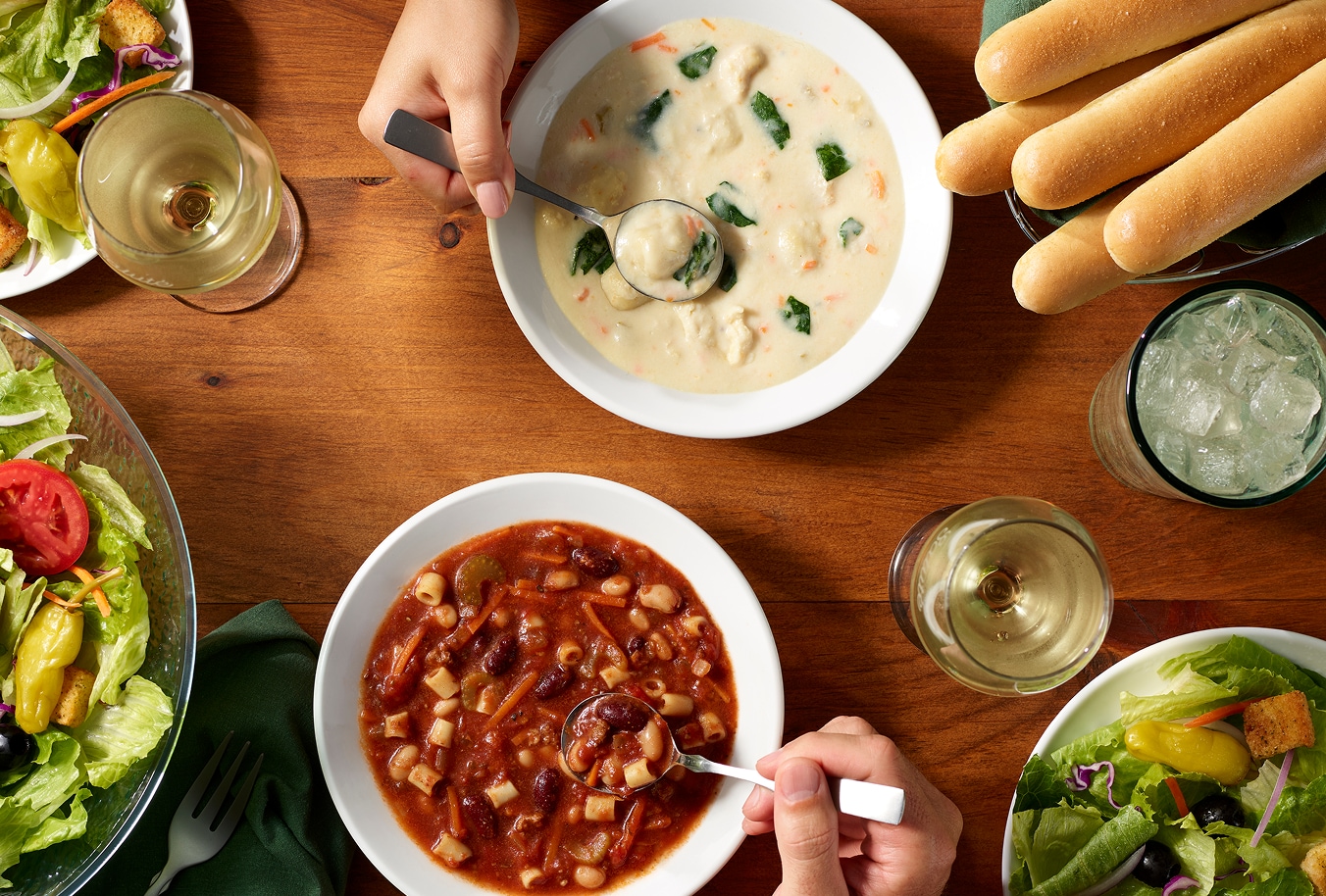 Soup, salad and breadsticks arranged on a dining table